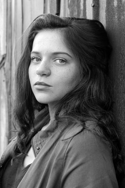 Striking black and white portrait of a young woman with expressive gaze and natural beauty.